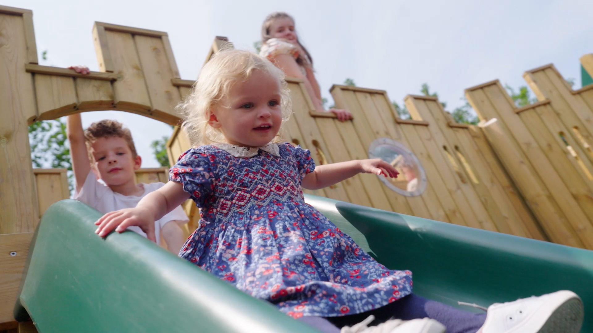 smiling-child-going-down-play-area-slide